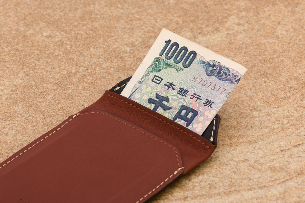 bellroy-elements-sleeve-wallet-cognac-texture-japan-webのメインポケットに紙幣を折り畳んで収納している画像